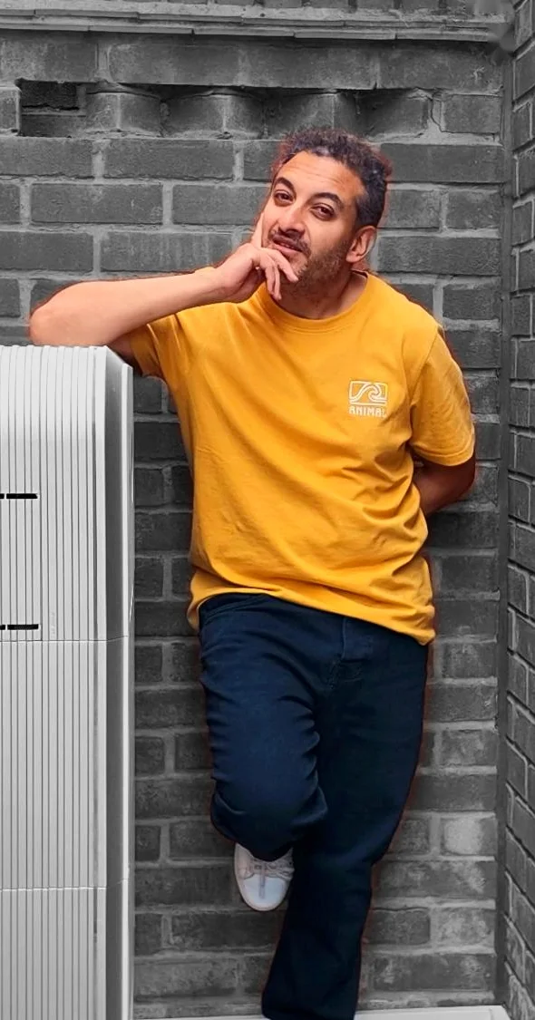 Munty leaning on the home battery in a narrow brick alcove, hand on his chin